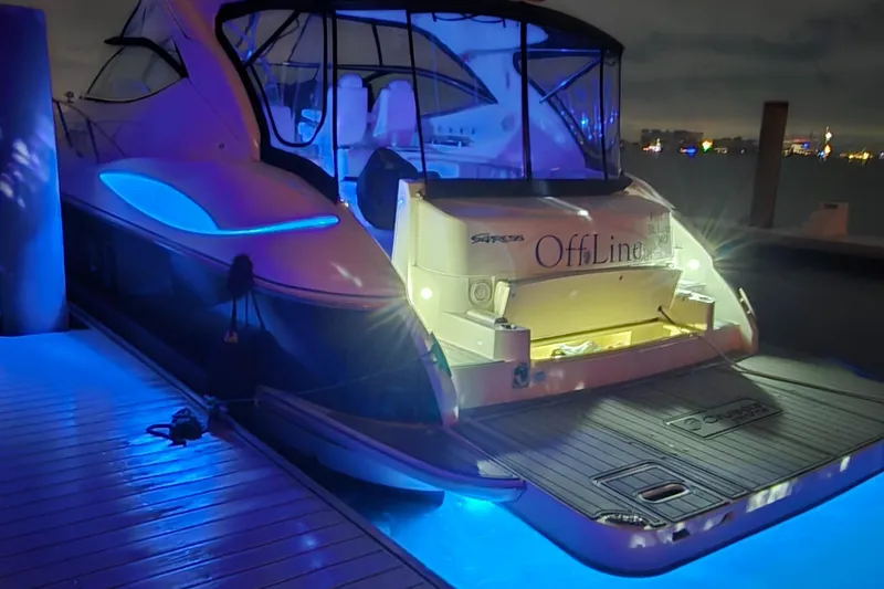 Slide: The Image of 2006 Cruisers Yachts 52 Express with blue LED lights at night docked. - 8