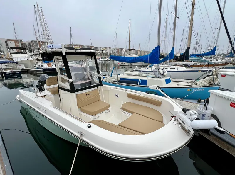 Slide: The Image of 2022 Bayliner Trophy T22CC boat docked in marina with sailboats. - 0