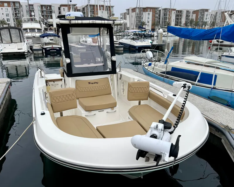 Slide: The Image of 2022 Bayliner Trophy T22CC boat docked in marina, featuring beige seating and modern design. - 5