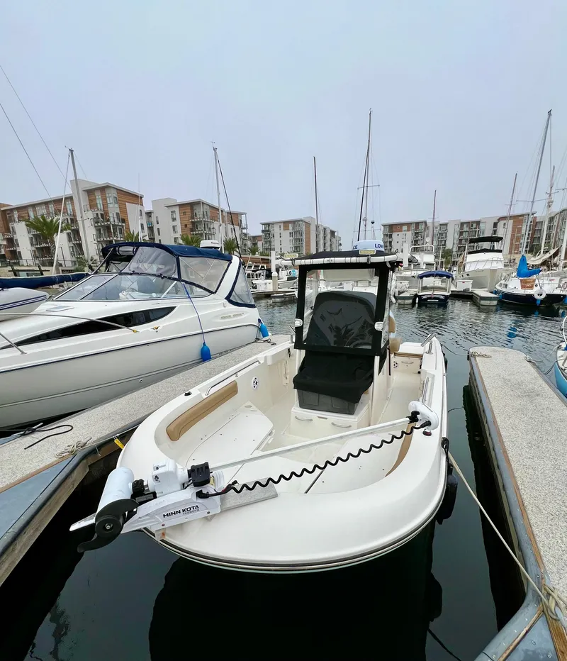 Slide: The Image of 2022 Bayliner Trophy T22CC boat docked in a marina with other vessels. - 7