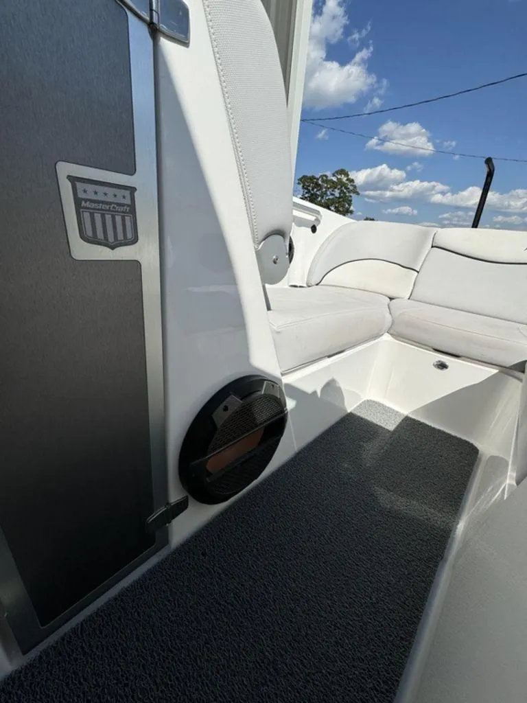 Slide: The Image of 2018 MasterCraft X23 boat interior with white seating and speaker. - 11