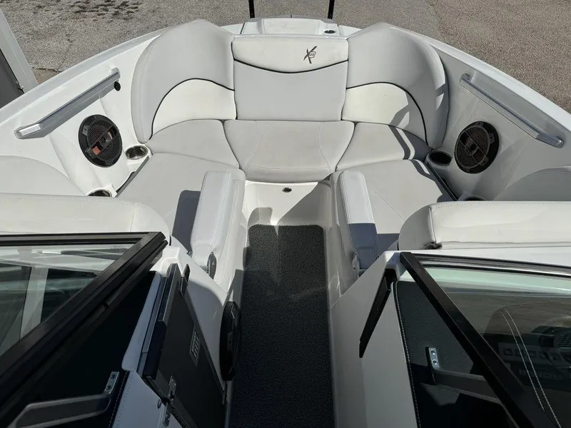 Slide: The Image of 2018 MasterCraft X23 boat interior with white seating and speakers. - 12