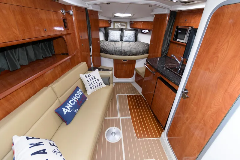 Slide: The Image of 2008 Four Winns V338 cabin interior with cozy seating, kitchenette, and bed. - 10