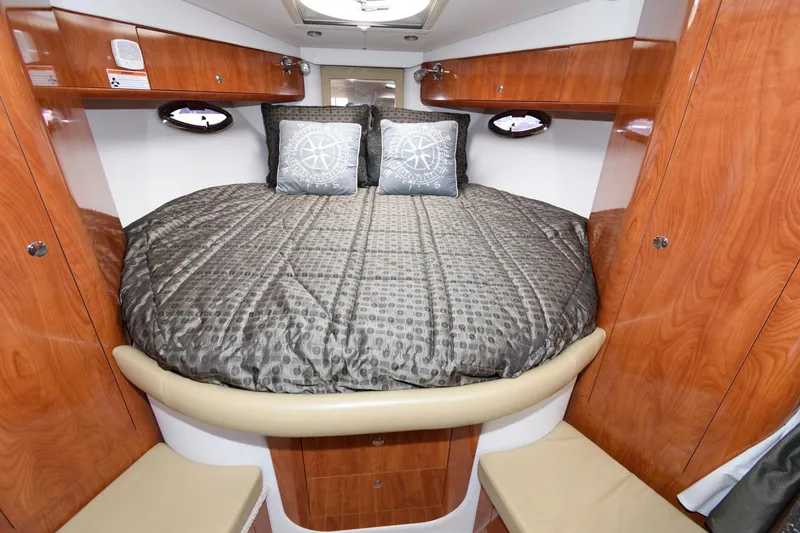Slide: The Image of 2008 Four Winns V338 cabin interior with wood finish and cozy bedding. - 12