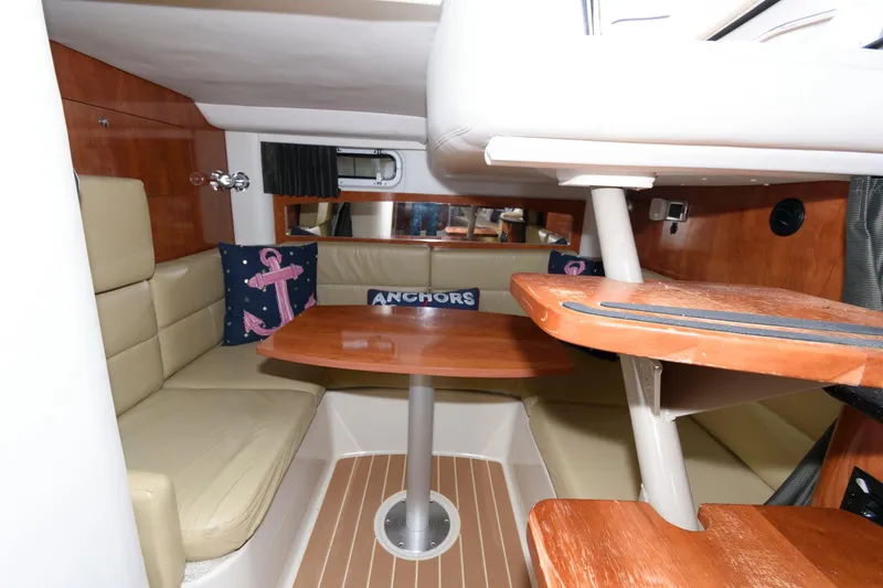 Slide: The Image of 2008 Four Winns V338 cabin interior with seating, table, and nautical-themed decor. - 14