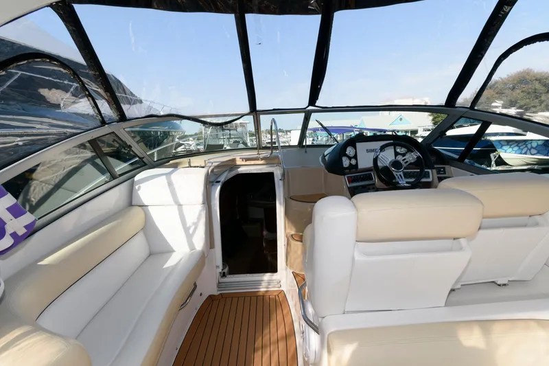 Slide: The Image of Interior view of 2008 Four Winns V338 boat, featuring beige seating and wooden flooring. - 5