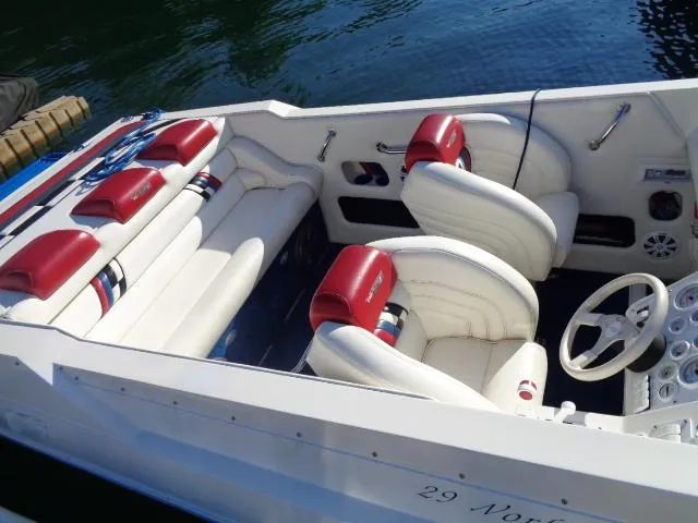 Slide: The Image of 2001 Warlock 29 World Class boat interior with white and red seating, docked on water. - 1