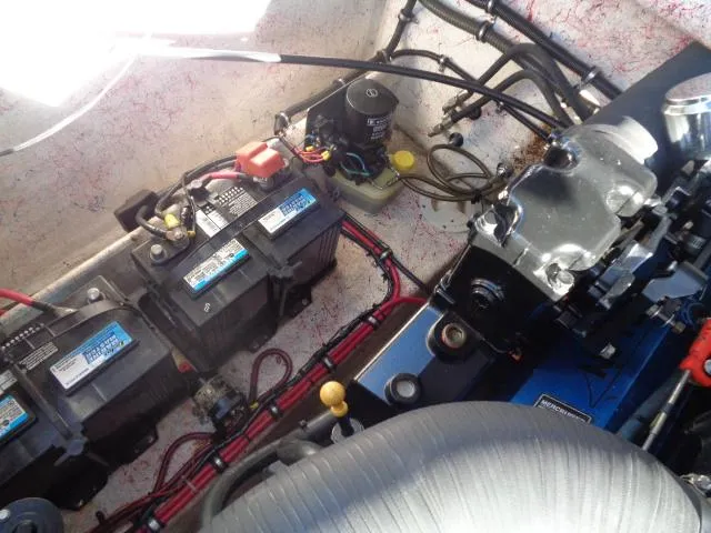 Slide: The Image of Engine compartment of a 2001 Warlock 29 World Class boat with visible batteries and wiring. - 22