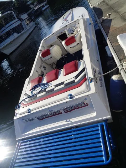 Slide: The Image of 2001 Warlock 29 World Class boat docked, featuring red and white seating, sleek design. - 4