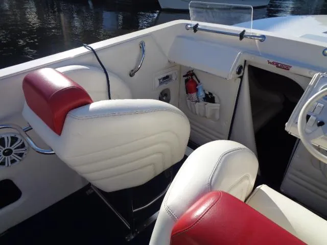 Slide: The Image of 2001 Warlock 29 World Class boat interior with red and white seating and dashboard details. - 6
