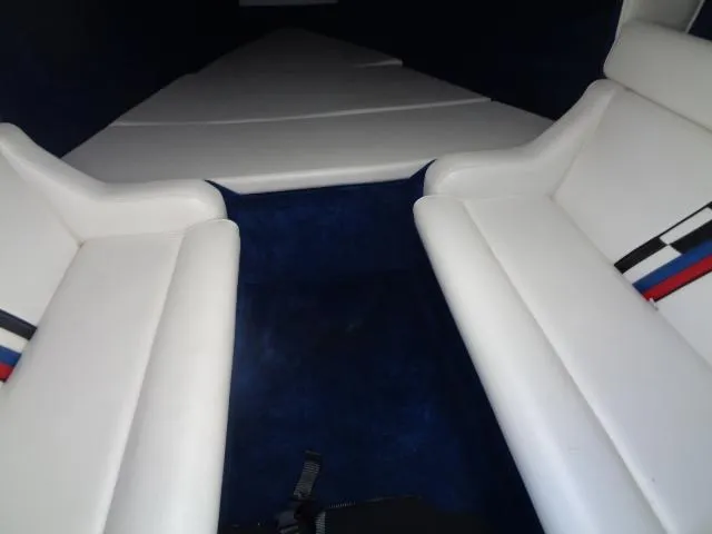 Slide: The Image of Interior of 2001 Warlock 29 World Class boat with white seating and blue carpet. - 9