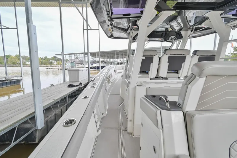 Slide: The Image of 2021 Pursuit S 428 Sport boat interior at dock, showcasing seating and helm area. - 20