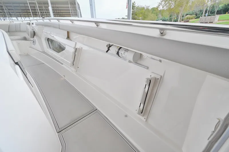 Slide: The Image of 2021 Pursuit S 428 Sport boat interior with storage compartments and safety equipment. - 36