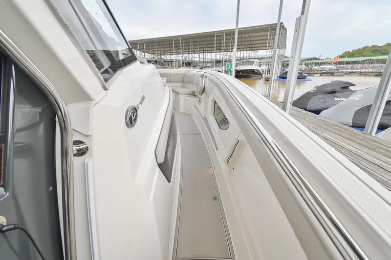 Slide: The Image of 2021 Pursuit S 428 Sport boat docked, showcasing sleek design and spacious deck area. - 37