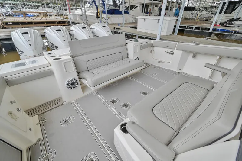 Slide: The Image of 2021 Pursuit S 428 Sport boat interior with cushioned seating and multiple outboard engines. - 8