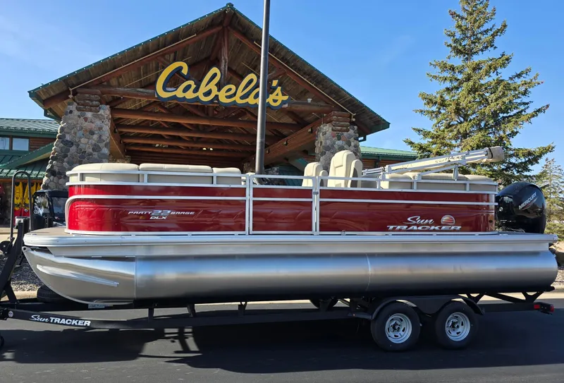 The Image of 2025 Sun Tracker Party Barge 22 DLX pontoon boat outside Cabela's store. - 0