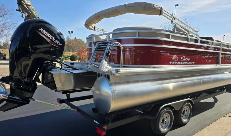 Slide: The Image of 2025 Sun Tracker Party Barge 22 DLX pontoon boat on trailer with Mercury outboard motor. - 2