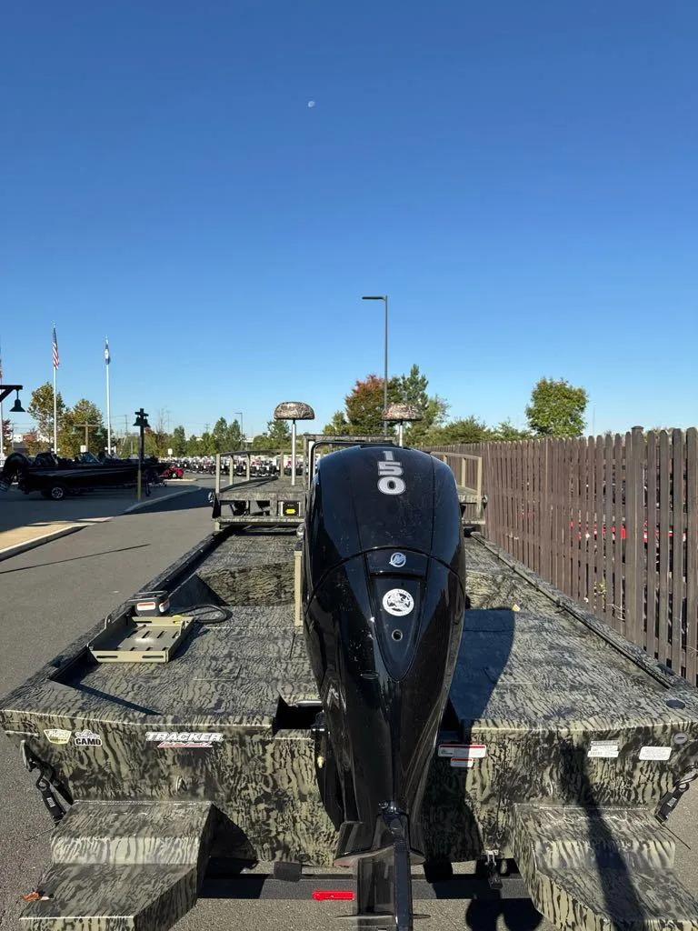 Slide: The Image of 2025 Tracker Grizzly 2072 CC Sportsman boat on trailer, parked outdoors. - 3