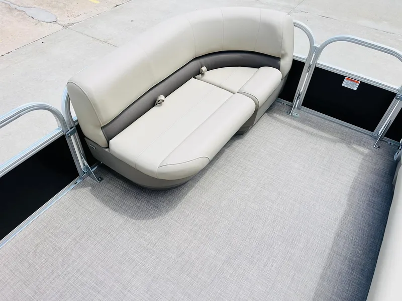 Slide: The Image of 2025 Sun Tracker Party Barge 16 DLX interior with beige seating and gray flooring. - 13