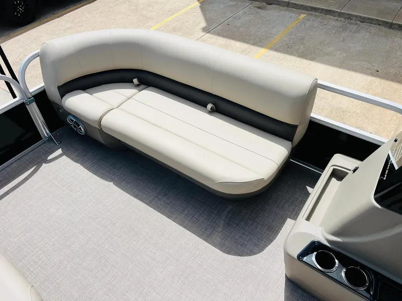 Slide: The Image of 2025 Sun Tracker Party Barge 16 DLX interior with beige seating and cup holders. - 17