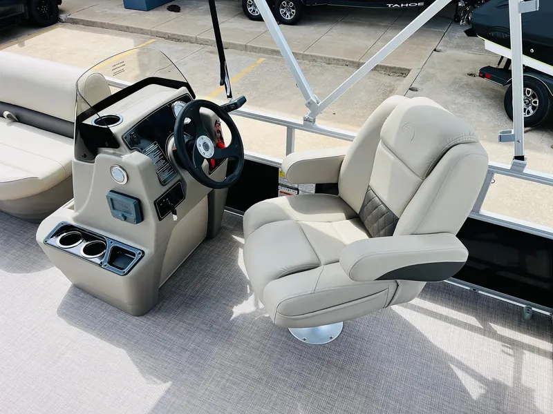Slide: The Image of Sun Tracker Party Barge 16 DLX 2025 interior with captain's chair and console. - 23