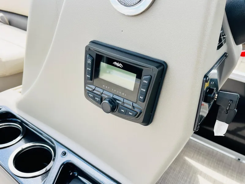 Slide: The Image of 2025 Sun Tracker Party Barge 16 DLX dashboard with stereo system and cup holders. - 24