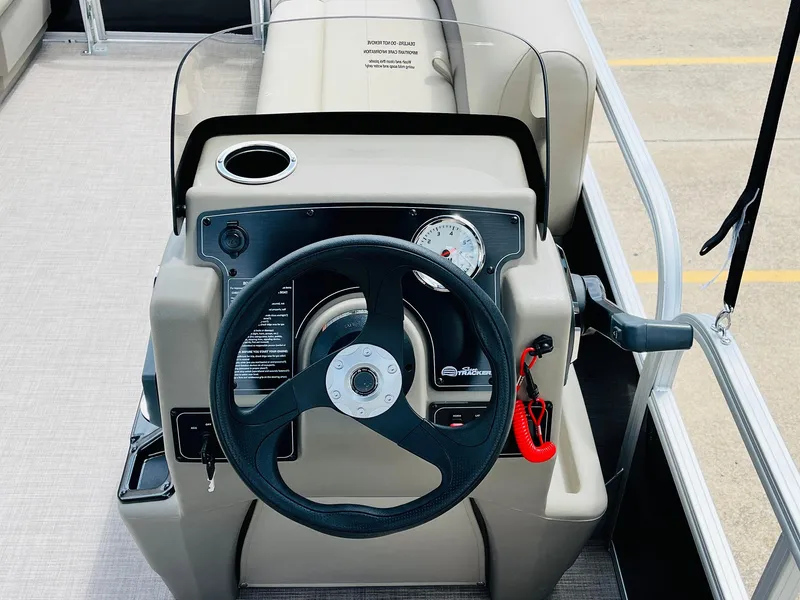 Slide: The Image of 2025 Sun Tracker Party Barge 16 DLX steering console with modern controls and cup holder. - 25