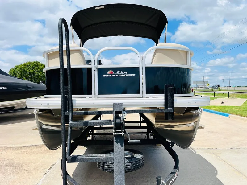Slide: The Image of 2025 Sun Tracker Party Barge 16 DLX pontoon boat on trailer, sunny day. - 3
