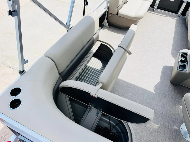 Slide: The Image of 2025 Sun Tracker Party Barge 16 DLX interior with open storage compartment and cup holders. - 30
