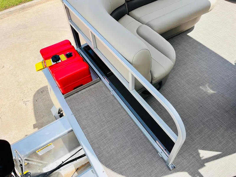 Slide: The Image of 2025 Sun Tracker Party Barge 16 DLX interior with seating and red fuel tank. - 33
