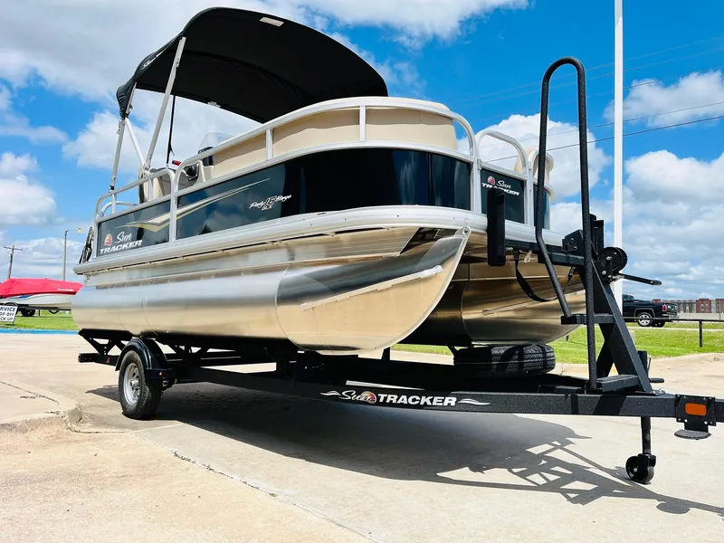 Slide: The Image of 2025 Sun Tracker Party Barge 16 DLX pontoon boat on trailer, sunny day. - 4