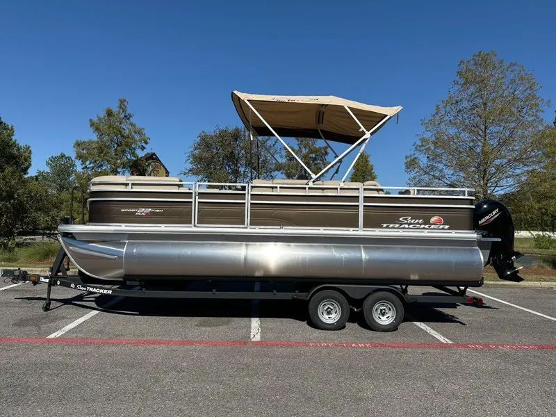 The Image of 2025 Sun Tracker SportFish 22 XP3 pontoon boat parked in a lot. - 0
