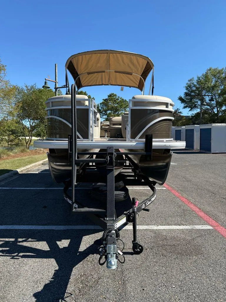 Slide: The Image of 2025 Sun Tracker SportFish 22 XP3 pontoon boat on trailer in parking lot. - 3