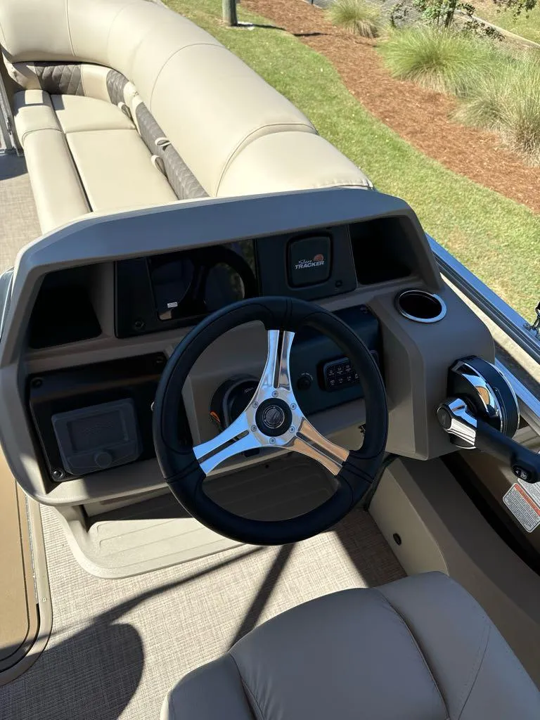 Slide: The Image of 2025 Sun Tracker SportFish 22 XP3 boat interior with steering wheel and control panel. - 7