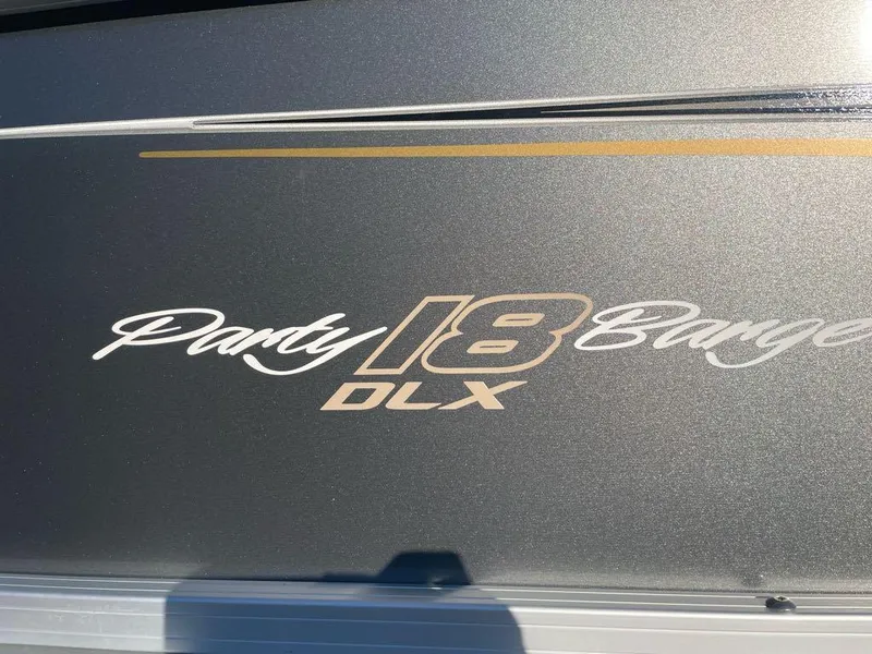 Slide: The Image of 2025 Sun Tracker Party Barge 18 DLX logo on boat exterior. - 2