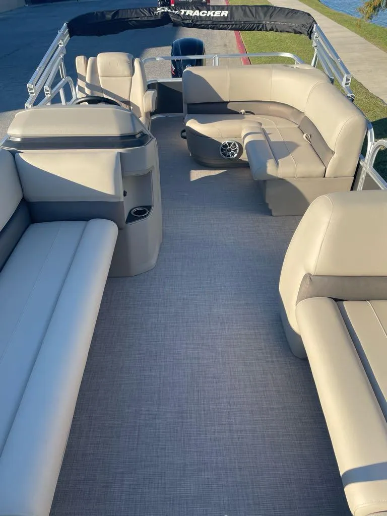 Slide: The Image of 2025 Sun Tracker Party Barge 18 DLX interior with beige seating and spacious layout. - 4