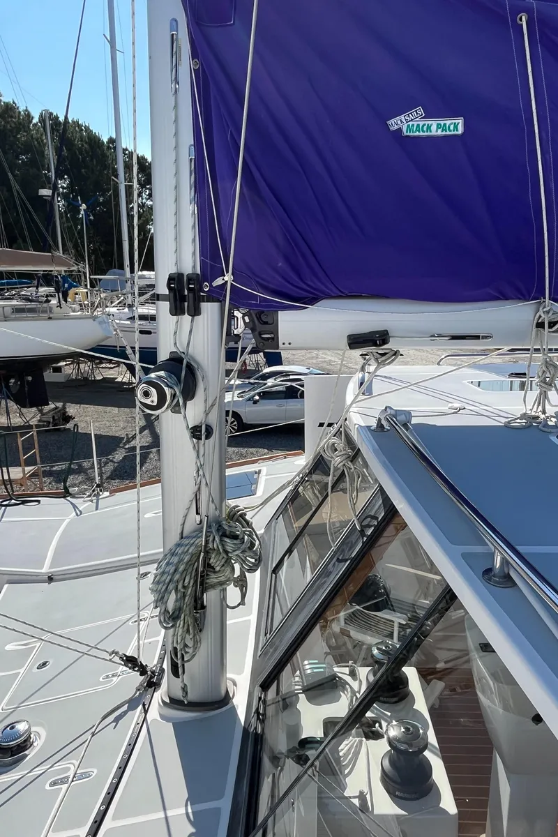 Slide: The Image of 2018 Maine Cat 38 Electric sailboat with purple sail cover, docked at marina. - 23