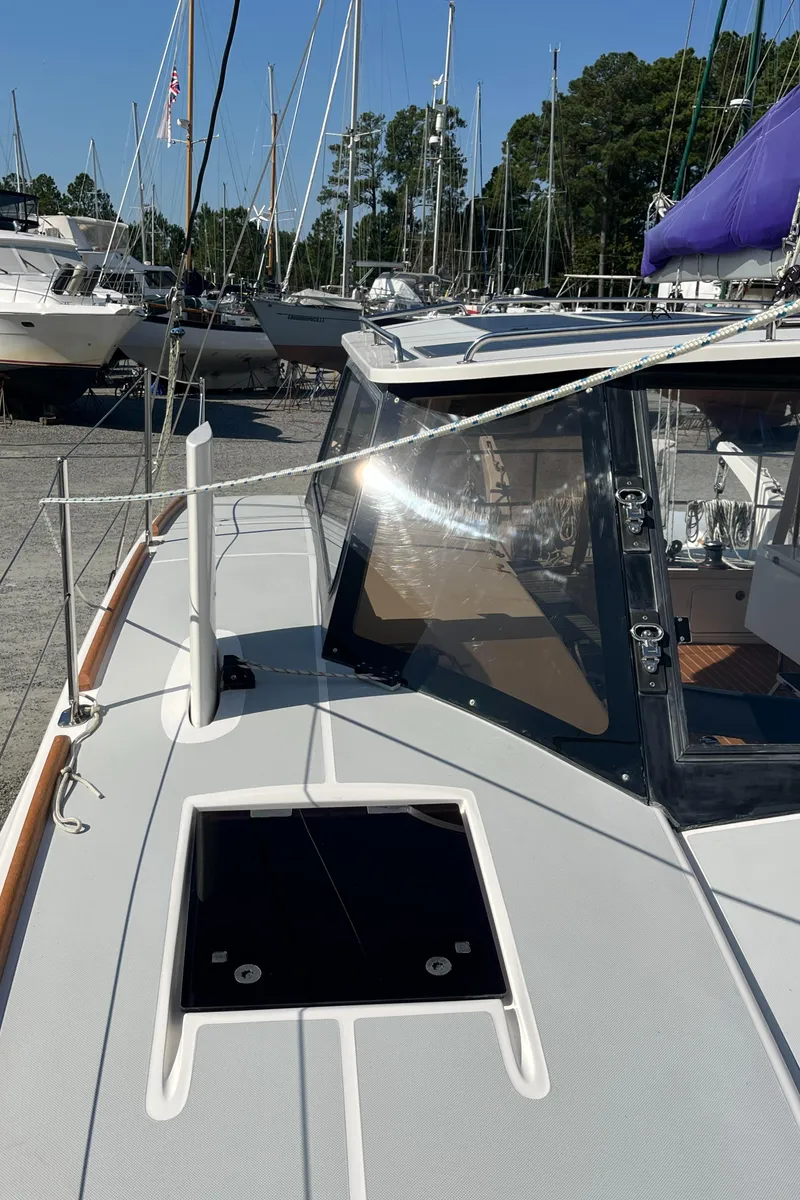 Slide: The Image of 2018 Maine Cat 38 Electric sailboat deck with open hatch, docked in marina. - 31