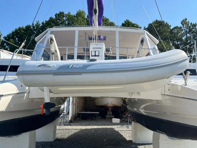 Slide: The Image of 2018 Maine Cat 38 Electric catamaran with inflatable dinghy, docked outdoors. - 4