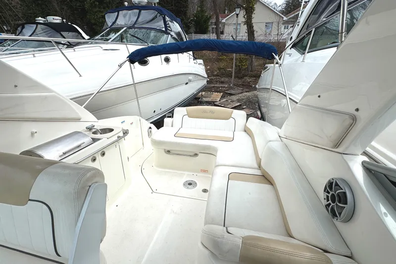 Slide: The Image of 2010 Sea Ray 280 Sundancer boat interior with white seating and outdoor view. - 13