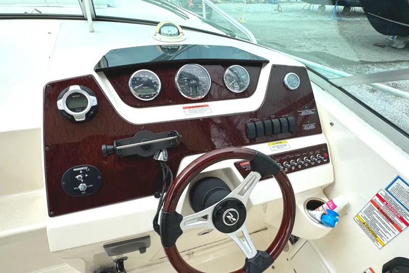 Slide: The Image of Dashboard of a 2010 Sea Ray 280 Sundancer boat with gauges and steering wheel. - 15