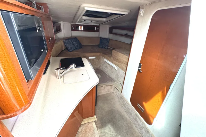 Slide: The Image of 2010 Sea Ray 280 Sundancer cabin interior with kitchenette and seating area. - 17