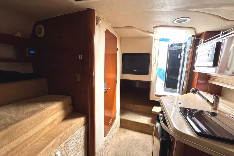 Slide: The Image of Interior of 2010 Sea Ray 280 Sundancer, featuring kitchenette, seating, and modern amenities. - 20