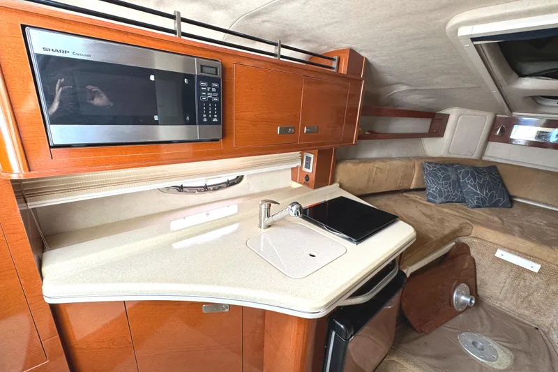 Slide: The Image of Interior of 2010 Sea Ray 280 Sundancer with kitchenette and seating area. - 23