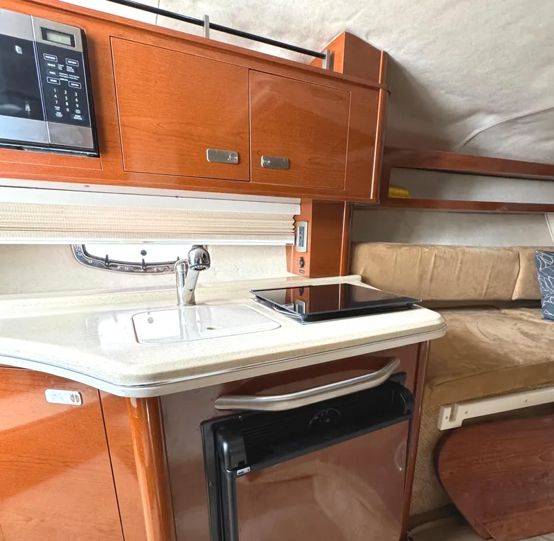 Slide: The Image of Interior of 2010 Sea Ray 280 Sundancer with kitchenette and seating area. - 24