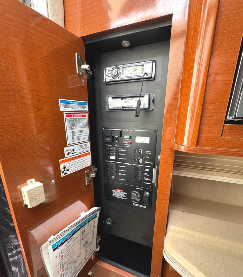 Slide: The Image of Electrical panel inside 2010 Sea Ray 280 Sundancer boat, featuring controls and stereo system. - 25