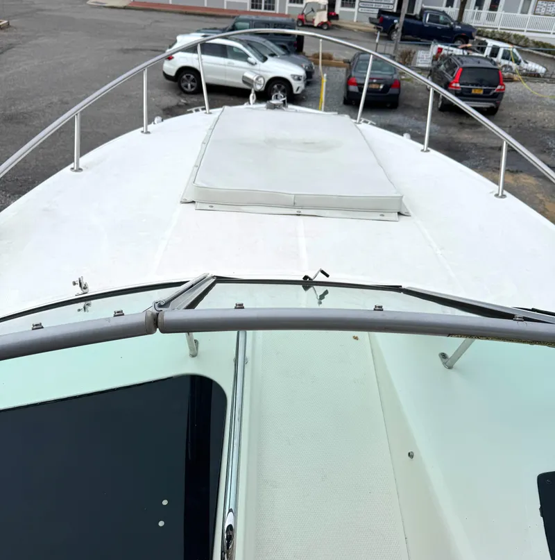 Slide: The Image of 2010 Sea Ray 280 Sundancer boat deck with railing and hatch, parked in a marina. - 8