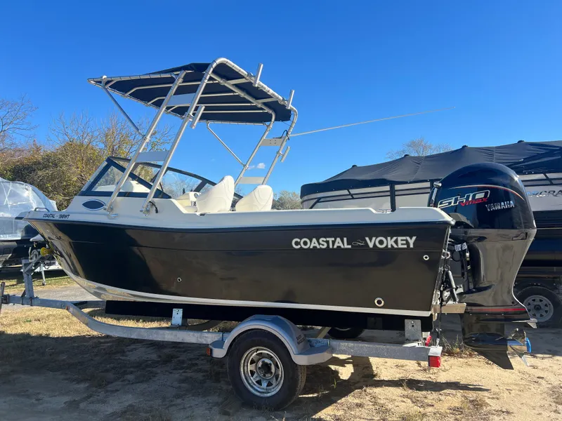 Slide: The Image of 2024 Coastal 198 WT boat on trailer with Yamaha engine, under clear blue sky. - 1