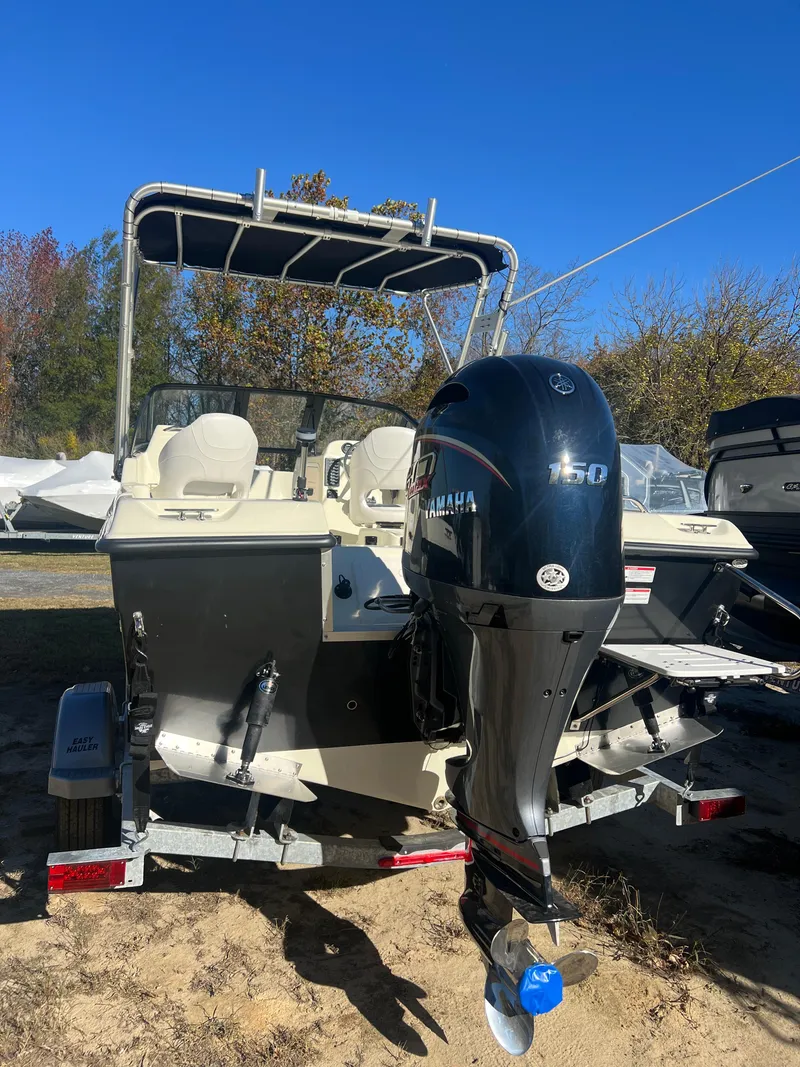 Slide: The Image of 2024 Coastal 198 WT boat with Yamaha 150 outboard motor, parked on a trailer. - 2