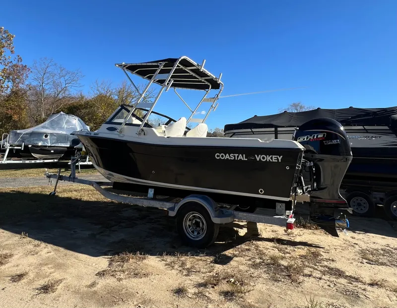 Slide: The Image of 2024 Coastal 198 WT boat on trailer, parked outdoors under clear blue sky. - 5